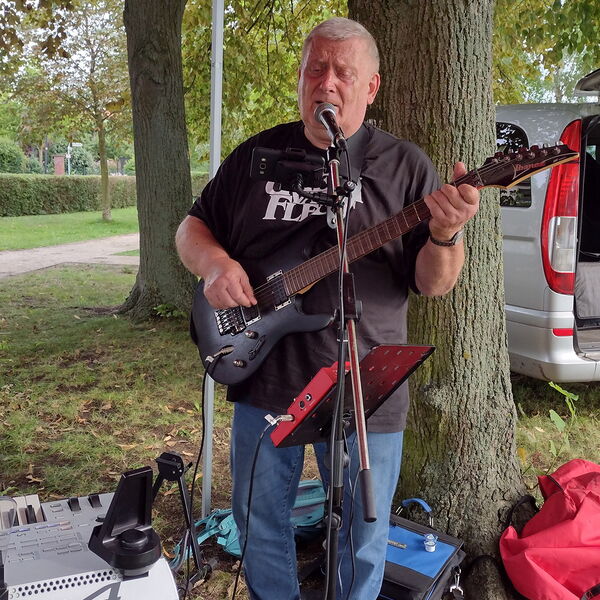 Ein Gitarrenspieler mit Mikrofonständer vor sich.