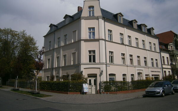 Ein imposantes Gebäude an einer Straßen Ecke.