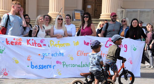 Menschen mit Plakaten bei der Demonstration gegen die Kita-Reform