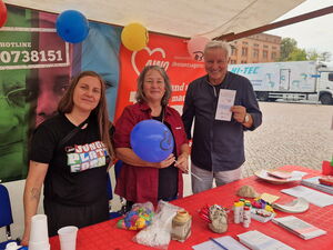 Stand der AWO Ehrenamtsagentur mit Info-Material und Luftballons. Zwei Frauen und ein Mann. Frau links trägt ein schwarzes T-Shirt der AWO junge Plattform.