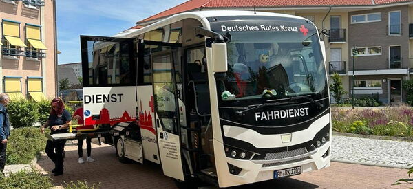 Reisebus von Deutschen Roten Kreuz steht vor Seniorenzentrum.