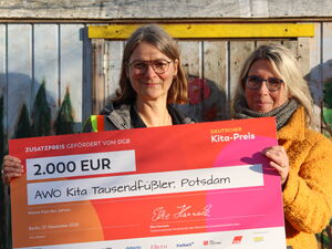 2 Frauen halten einen großen Preis-Scheck in die Kamera und lächeln. Preisgeld: 2.000 Euro.