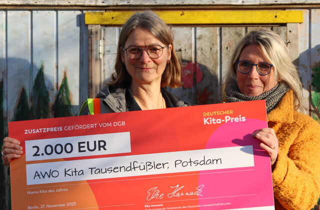 2 Frauen halten einen großen Preis-Scheck in die Kamera und lächeln. Preisgeld: 2.000 Euro.