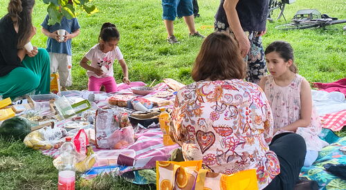 Picknick. Erwachsene und Kinder auf Decken sitzend.