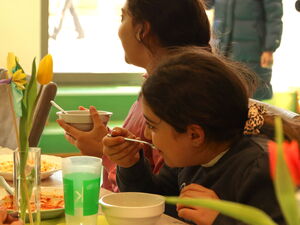 2 Mädchen am Tisch beim Essen.