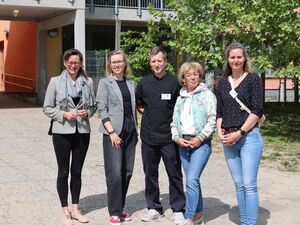 Gruppenbild: Draußen. Sonnenschein.  4 Frauen und ein Mann in der Mitte.