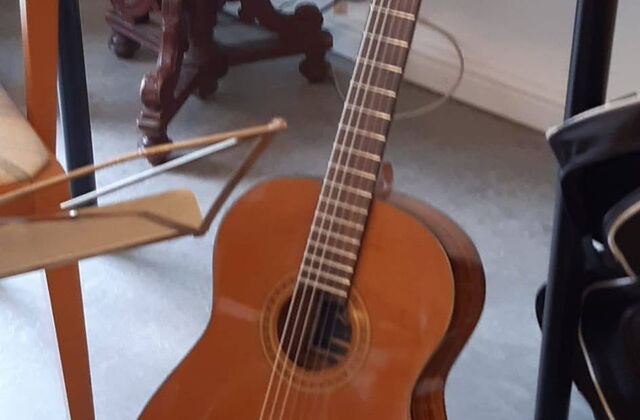 Gitarre lehnt an einem Tisch.