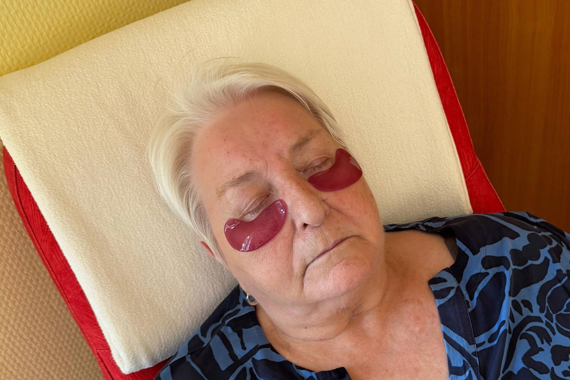 Seniorin beim Relaxen mit Augenmaske.