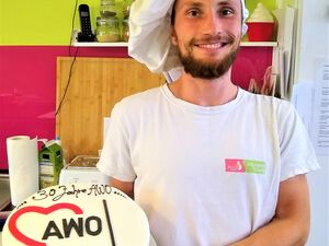 Bäcker mit der Torte zum 30 Jahre AWO Geburtstag. Auf der weißen Glasur der Torte steht: 30 Jahre AWO - AWO OV Ketzin