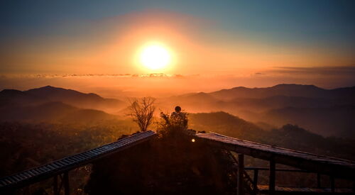 Ein Sonnenuntergang vor hügeliger Landschaft, warme friedliche Atmosphäre