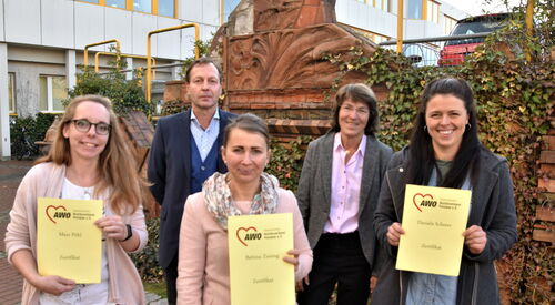 Auf dem Bild sind zu sehen im Vordergrund Bettina Zeising, Daniela Scherer und Maxi Pöhl, die ihre Zertifikate als Schulgesundheitsfachkräfte in der Hand haltern. Dahinter Stefan Zaborowski, Verantwortlich beim AWO Bezirksverband für die Zertifizierung