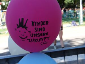 Lila Luftballon mit Aufdruck: Ein Kindergesicht und Text: Kinder sind unsere Zukunft.