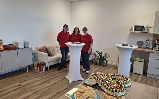 Raum mit Tisch und zwei Stehtischen, auf dem Tisch Kuchen und Obst- und Käsespieße, am Stehtisch stehen 3 Mitarbeiter der Sozialstation Bad Belzig