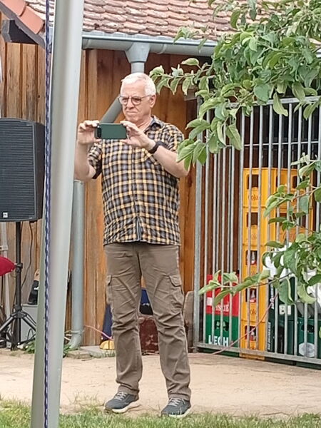 Älterer Mann macht mit Handy ein Foto.