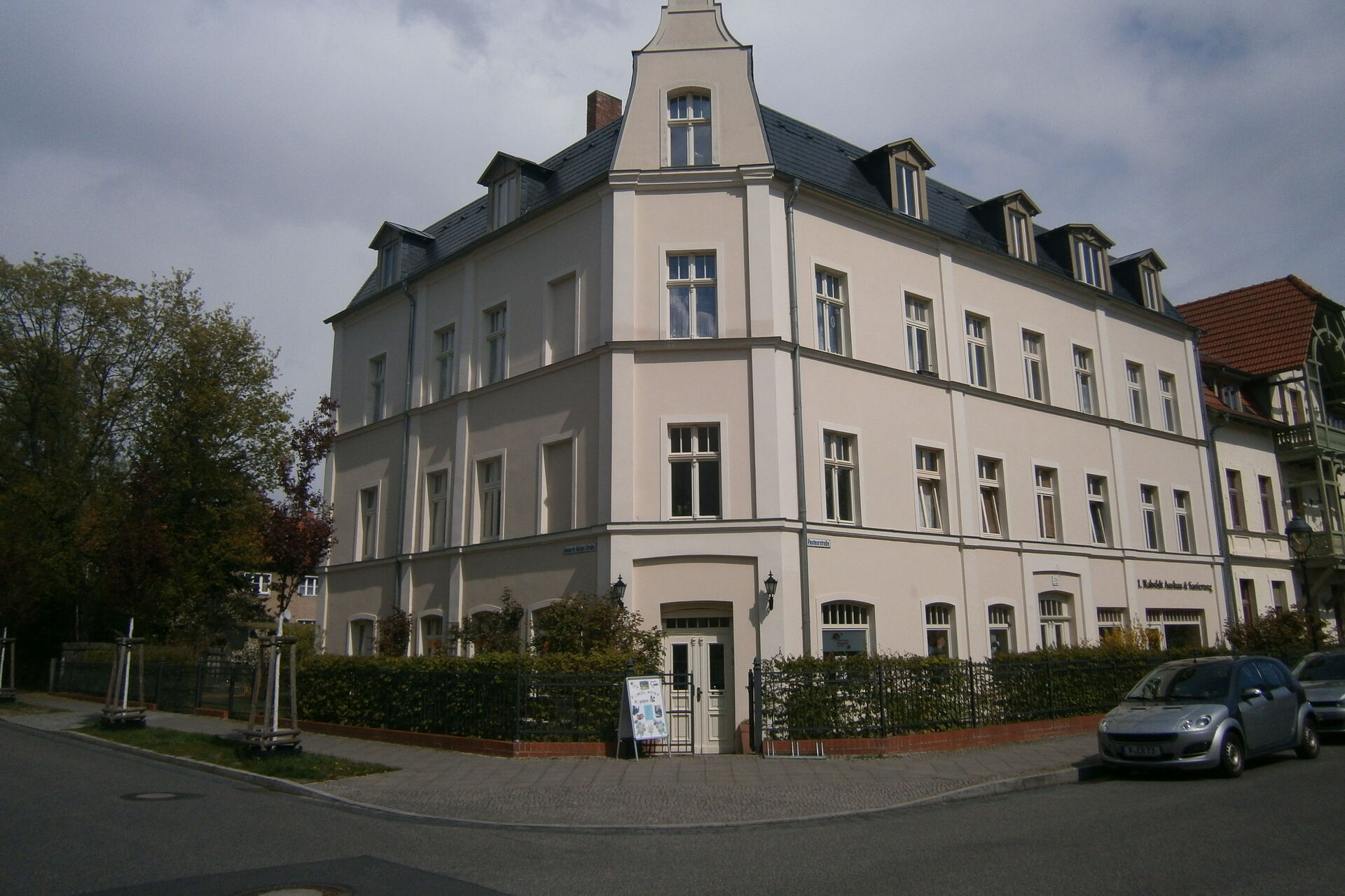 Ein imposantes Gebäude an einer Straßen Ecke.