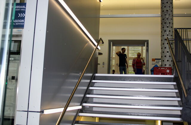 Eine Treppe zu beiden Seiten mit Geländer in einem Gebäude.