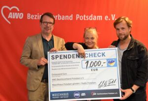 Drei Leute halten einen großen Scheck. Von links: Frank Smyrek, Radio Potsdam, Angela Schweers, AWO Potsdam, Mathias Paselk, Waschhaus Potsdam