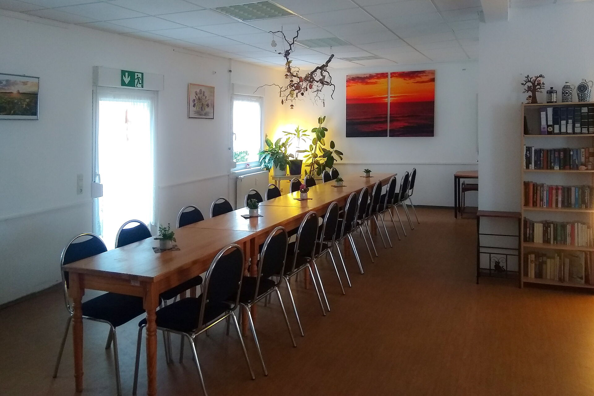 großer Raum, lange Tafel mit vielen Stühlen.