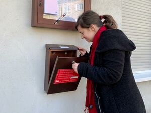 Eine Frau schaut in einen Briefkasten