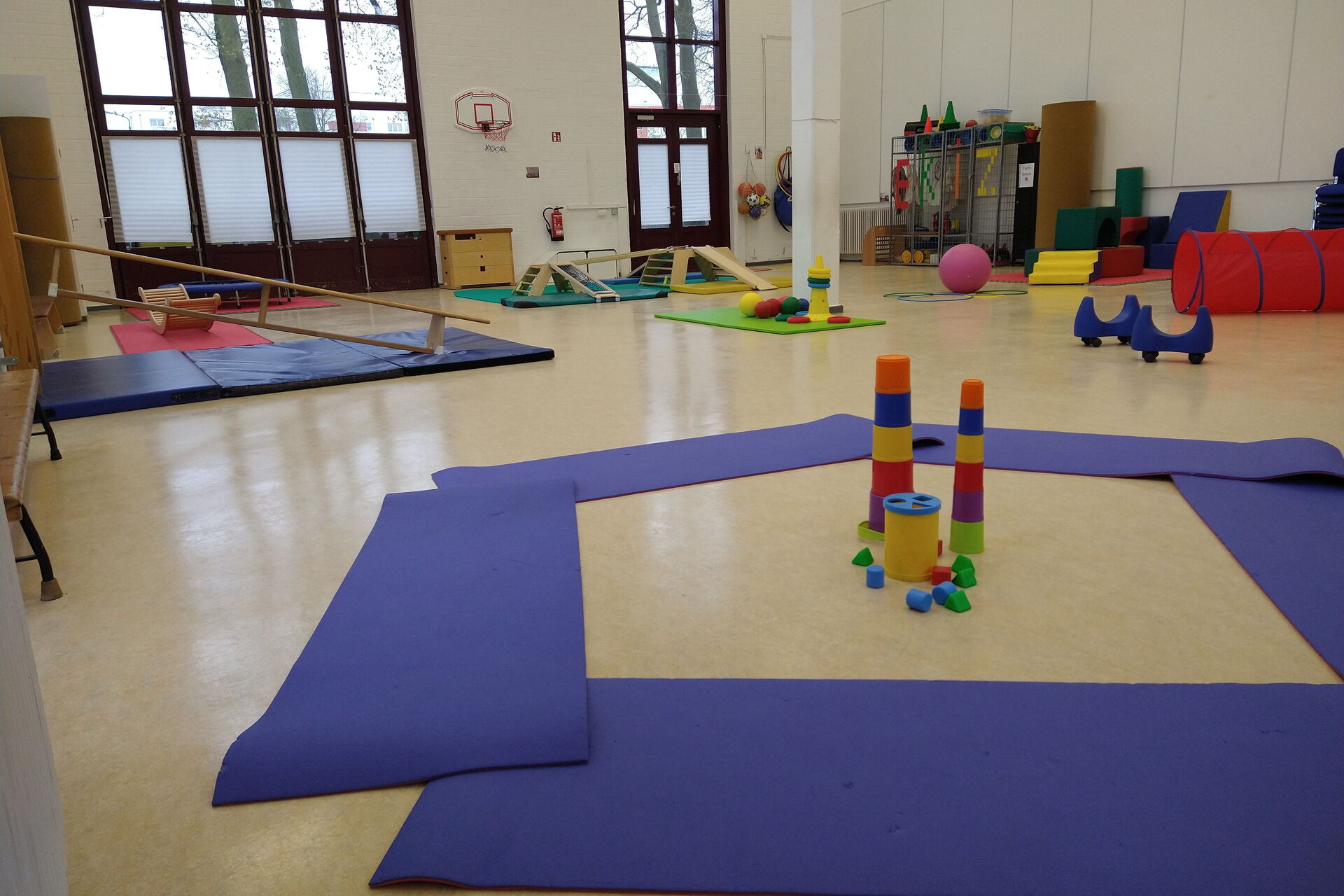 Turnhalle mit verschiedenen Sportelementen für Kleinkinder auf dem Boden