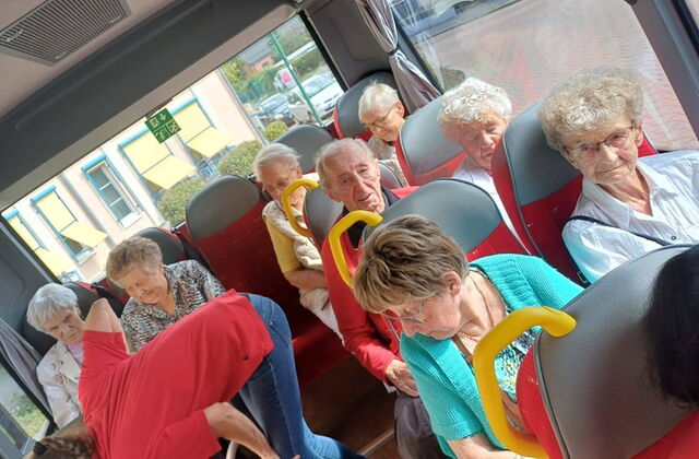 Senioren in einem Bus sitzend.