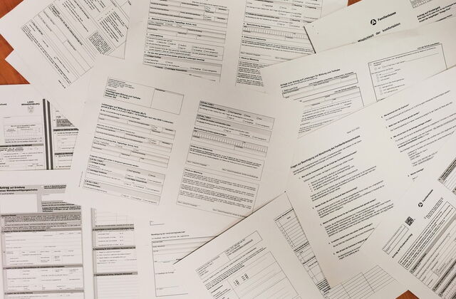 Ein Wust aus Antragsformularen. Familienkasse, Jobcenter
