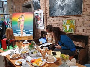 3 Frauen sitzen in einer Galerie. Vor ihnen ein reichgedeckter Tisch, an den Wänden Bildern. In der Ecke ein großes Bild auf eine Staffelei. Ein Bild an der Wand zeigt den Froschkönig. Frosch mit Krone.