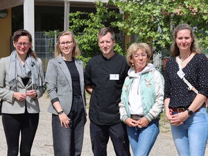 Gruppenbild: Draußen. Sonnenschein.  4 Frauen und ein Mann in der Mitte.