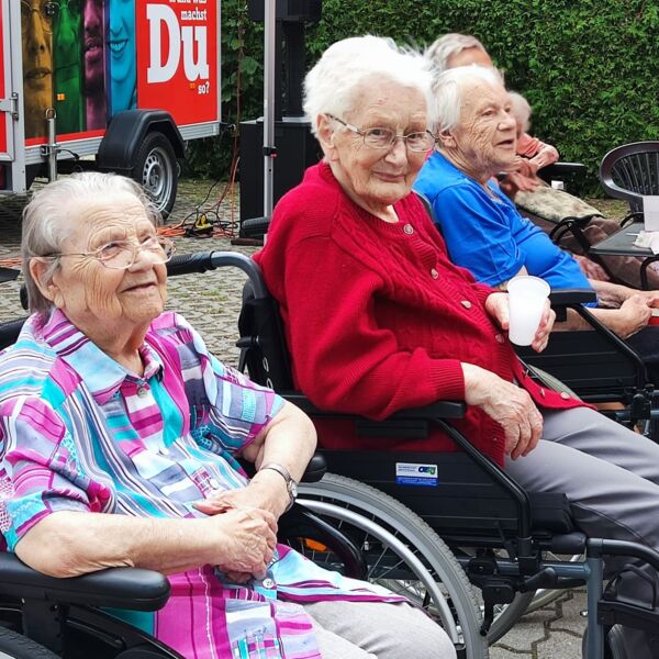 Hier sehen sie drei Frauen in Rollstühlen sitzend
