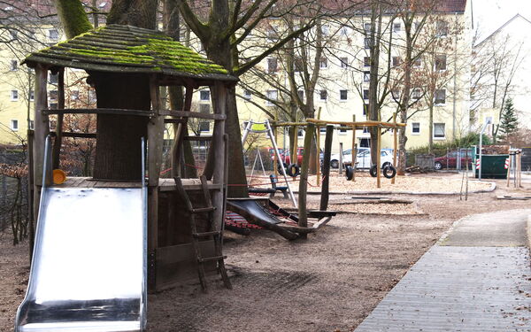 Draußen, Spielplatz, Kleines Klettergerüst mit Rutsche. Reifen-Schaukel mit mehren Reifen die an Ketten hängen.