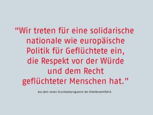 Roter Text: Wir treten für eine solidarische nationale wie europäische Politik für Geflüchtete ein, die Respekt vor der Würde und dem Recht geflüchteter Menschen hat. Schwarzer Text darunter: Aus dem neuen Grundsatzprogramm der Arbeiterwohlfahrt