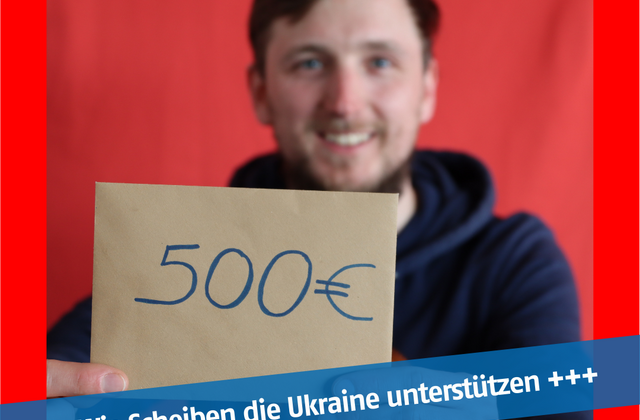 Ein Mann hält einen Briefumschlag hoch mit der Aufschrift: 500 Euro
