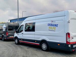 Zwei Hilfstransporter an einer Blechwand