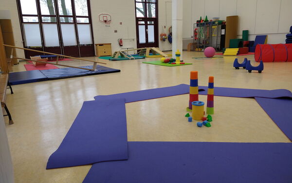 Turnhalle mit verschiedenen Sportelementen für Kleinkinder auf dem Boden