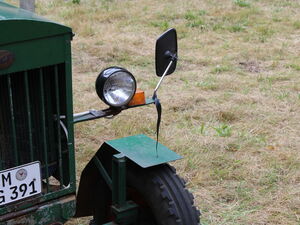 Kühler, Lampe und Rückspiegel eines Traktors von Nahem.