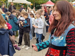 Platz vor der Schule, viele Kinder und auch Erwachsene stehen draußen.