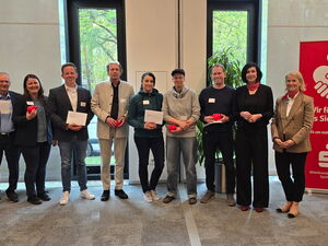 Gruppenfoto 10 Personen, 2. von rechts, Oberbürgermeisterin Aubel. Einige halten Briefe und rote Starschweine in der Hand.