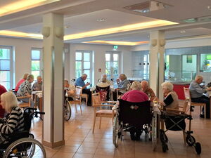 Speisesaal. Altere Menschen sitzen an vierer Tischen.