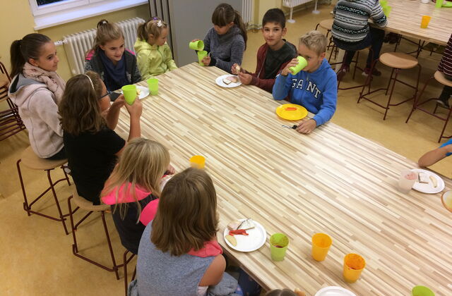 9 Kinder am Frühstückstisch beim Essen.