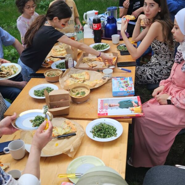 Hier sehen sie Menschen an einer Tafel beim Essen