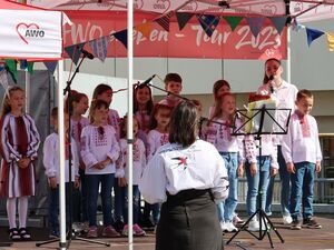 Kinderchor auf der Bühne. Mädchen und Jungen singen.