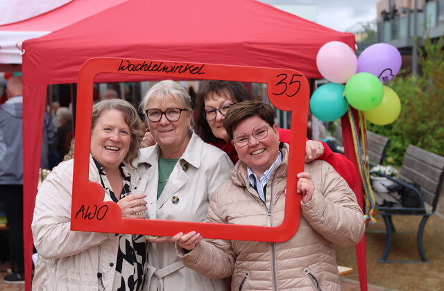 4 Frauen lächeln durch einen roten Bilderrahmen, den sie vor sich halten. In der oberen rechten Ecke steht eine 35.