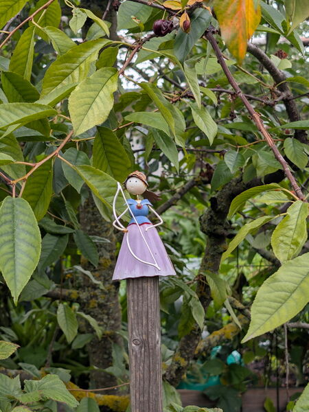 Gartendekoration. Eine Frau mit Kleid und Bogen.