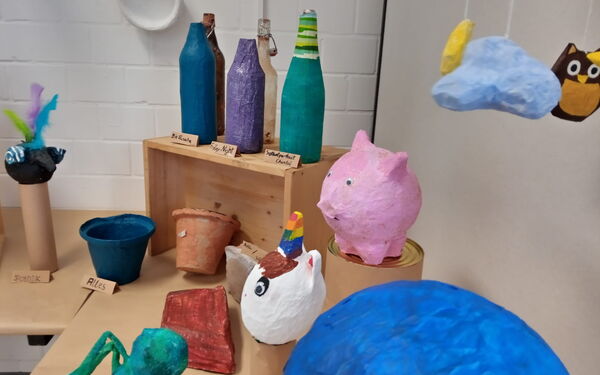 Pappmaschee Figuren, Ein rosa Schwein, weißes Einhorn mit Regenbogen-farben Horn, Blumentöpfe