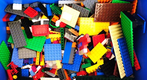 Blick in eine blaue Kiste gefüllt mit Lego-Bausteinen.