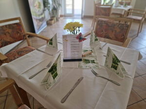 Gedeckter vierer Tisch mit Speisekarte.