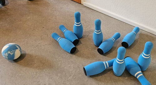 Weiche blaue Kegel und ein blau-weißer Ball auf Teppich.
