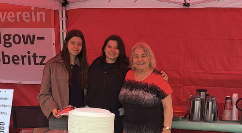 3 Frauen im Stand mit Kuchen und Kaffee.
