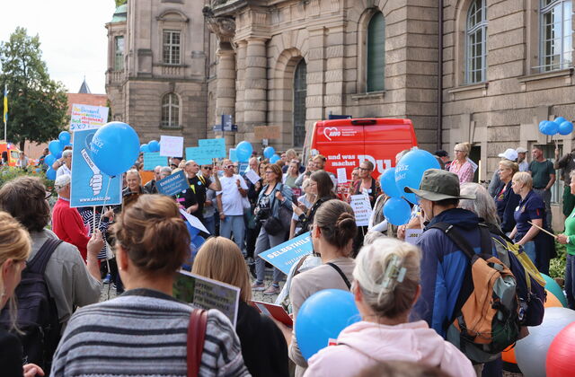 Protest. Viele Menschen vor dem Potsdamer Rathaus. Viele mit blauen Luftballons vom SEKIZ und viele recken ihre Protest Schilder nach oben.