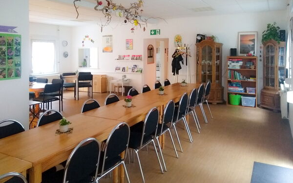 Lange Tafel in einem großen hellen Raum.